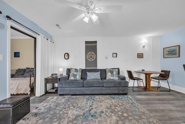 living room featuring a ceiling fan, baseboards, and wood finished floors