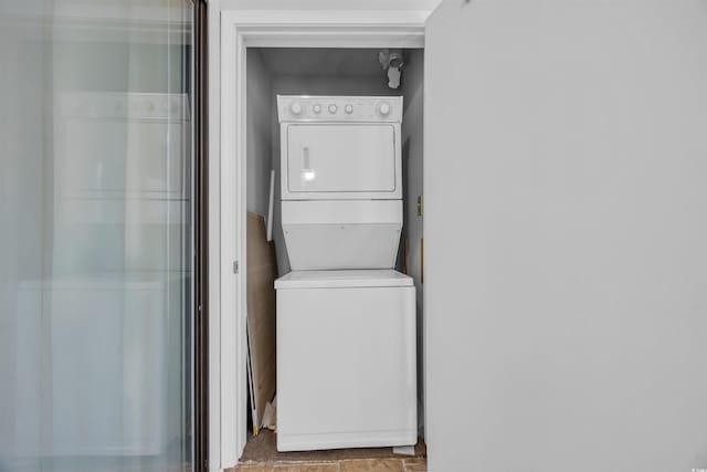 washroom featuring stacked washer and dryer and laundry area