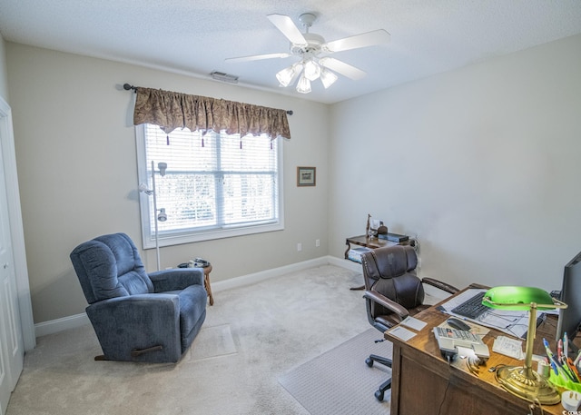 home office with light carpet, visible vents, baseboards, a ceiling fan, and a textured ceiling