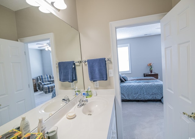 bathroom featuring connected bathroom, vanity, and a textured ceiling