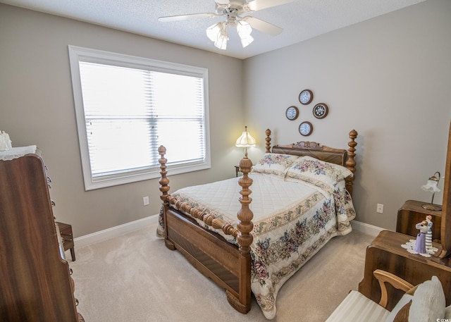 bedroom featuring light carpet, a textured ceiling, a ceiling fan, and baseboards