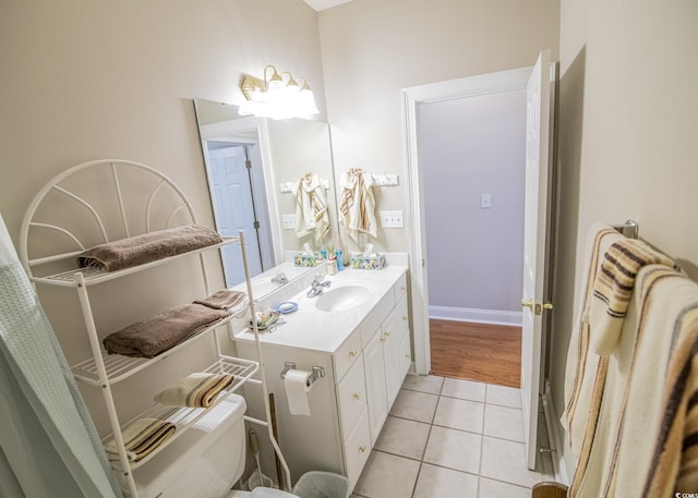 bathroom featuring toilet, tile patterned flooring, and vanity