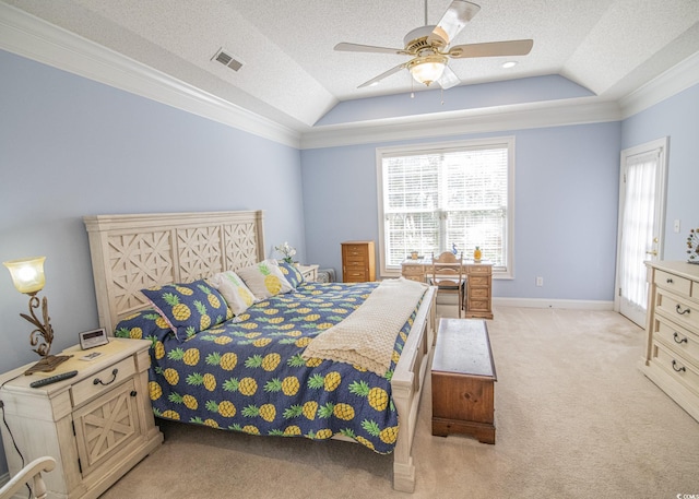 bedroom featuring light carpet, visible vents, a tray ceiling, and ornamental molding