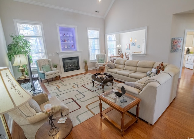 living room featuring a wealth of natural light, crown molding, and wood finished floors