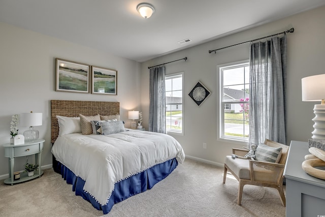 bedroom featuring visible vents, light carpet, and baseboards
