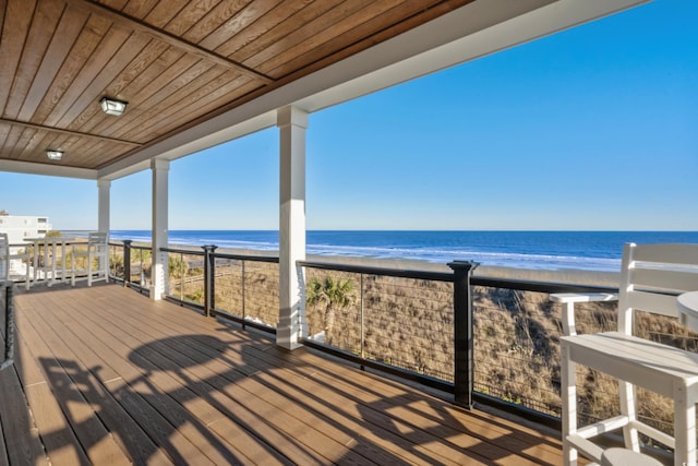 wooden deck with a view of the beach and a water view