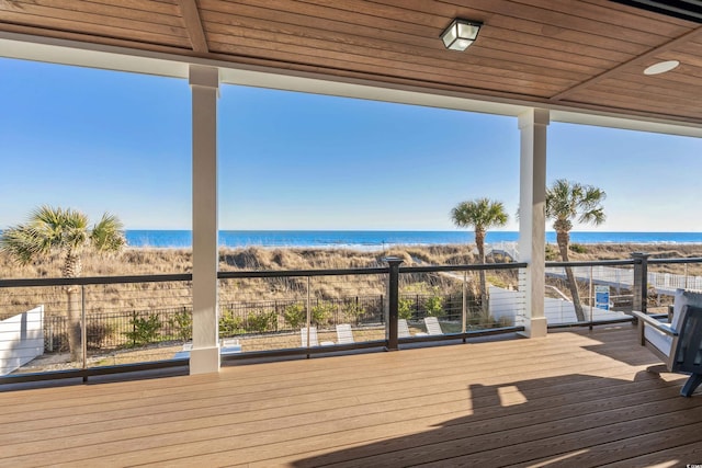 wooden terrace featuring a view of the beach and a water view