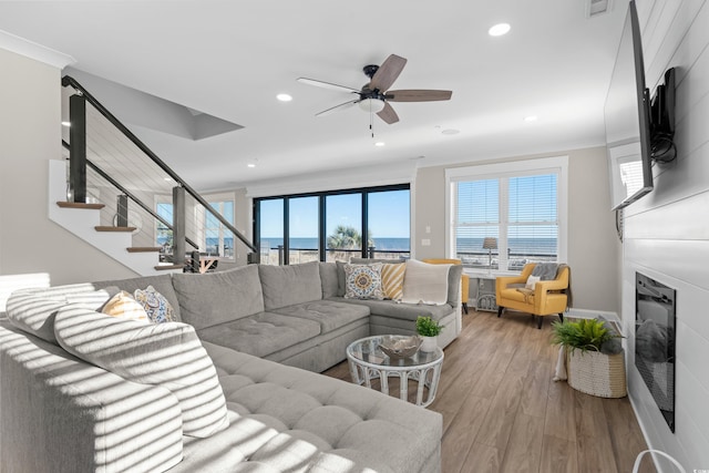 living area with light wood finished floors, stairway, a fireplace, and recessed lighting