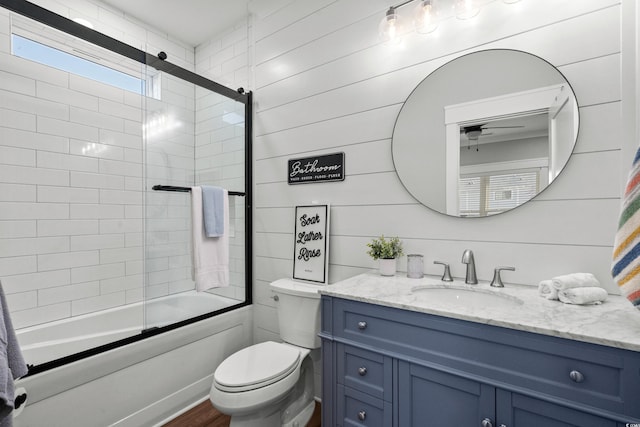 full bath featuring combined bath / shower with glass door, vanity, toilet, and wood finished floors