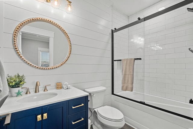 bathroom featuring toilet, enclosed tub / shower combo, and vanity