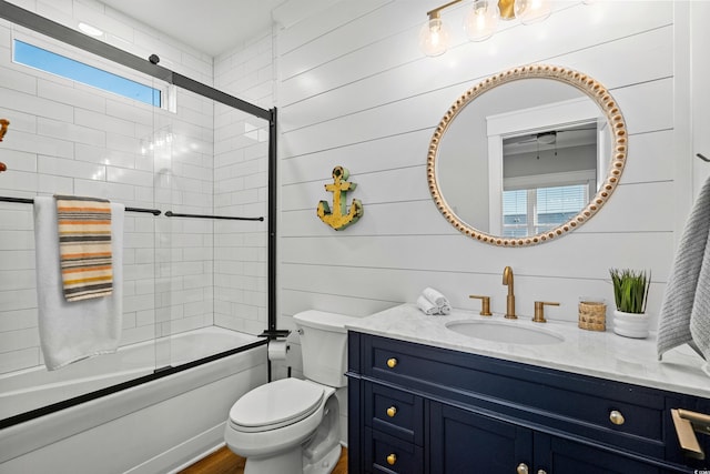 bathroom with toilet, combined bath / shower with glass door, and vanity