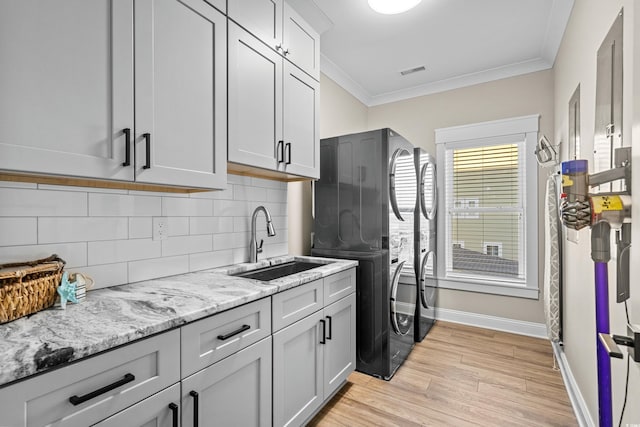 kitchen featuring visible vents, backsplash, a sink, and ornamental molding