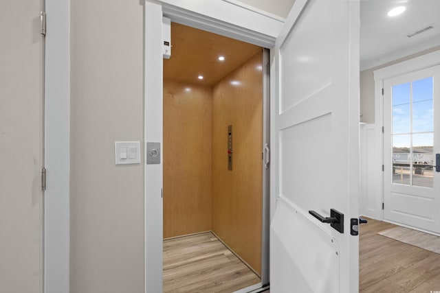 room details with recessed lighting, elevator, visible vents, and wood finished floors