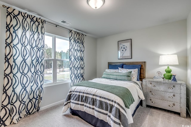 carpeted bedroom featuring visible vents and baseboards