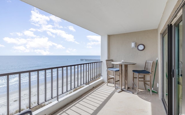 balcony featuring a water view and a view of the beach