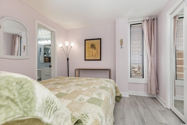 bedroom featuring light wood-style floors, ensuite bath, and baseboards