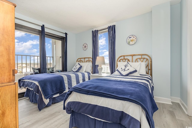 bedroom with a textured ceiling, wood finished floors, and baseboards