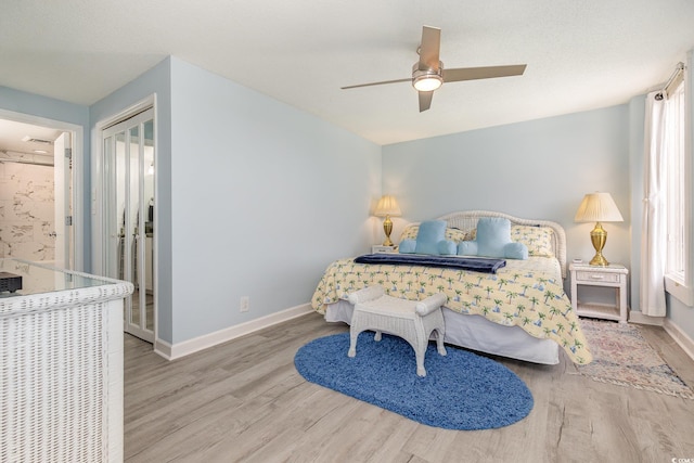 bedroom featuring a ceiling fan, a closet, baseboards, and wood finished floors