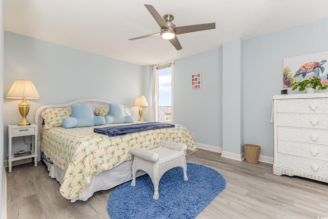 bedroom with a ceiling fan, baseboards, and wood finished floors