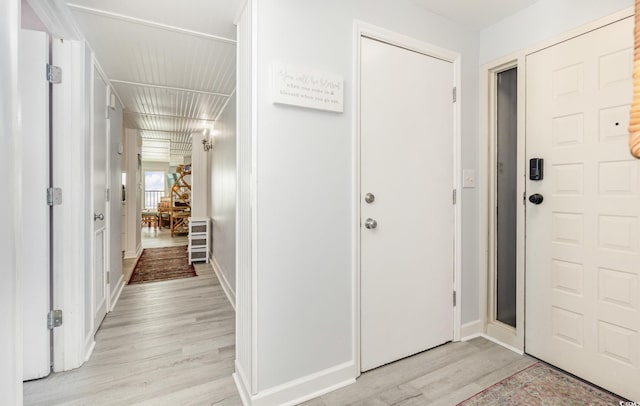 entryway with light wood finished floors and baseboards