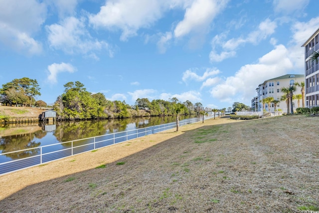 view of property's community with a water view and fence