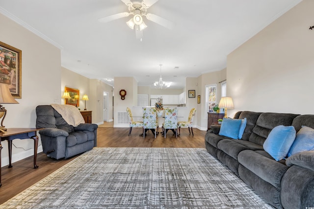 living area with crown molding, wood finished floors, visible vents, and baseboards