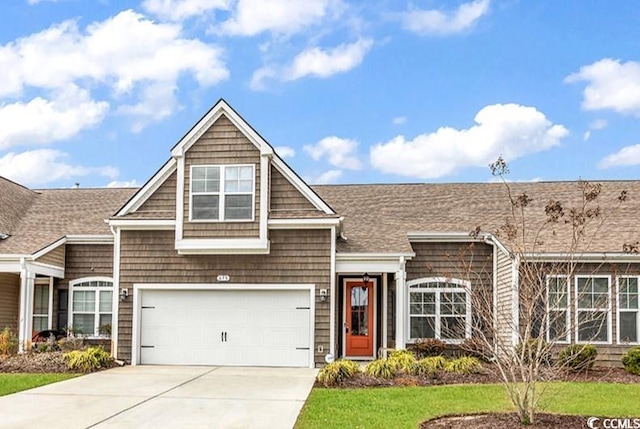 view of front of house with a garage, roof with shingles, and driveway