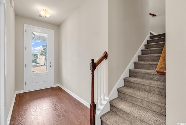 foyer featuring wood-type flooring, visible vents, and baseboards