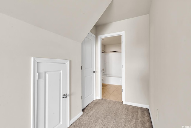 corridor featuring light carpet and baseboards