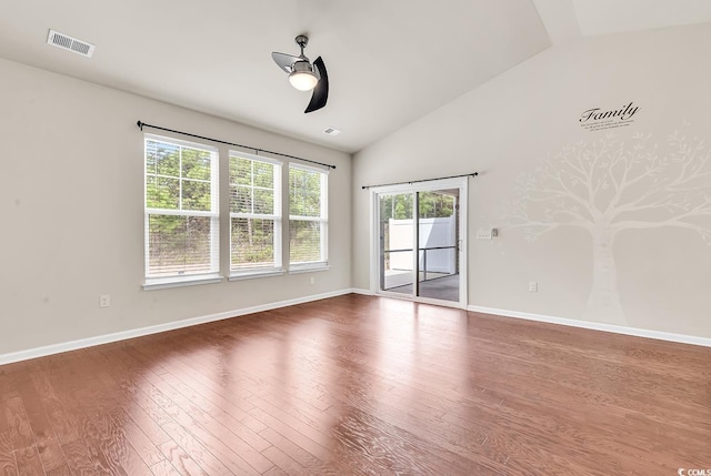 empty room with baseboards, visible vents, a ceiling fan, lofted ceiling, and wood finished floors