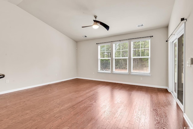 spare room with ceiling fan, baseboards, visible vents, and dark wood finished floors