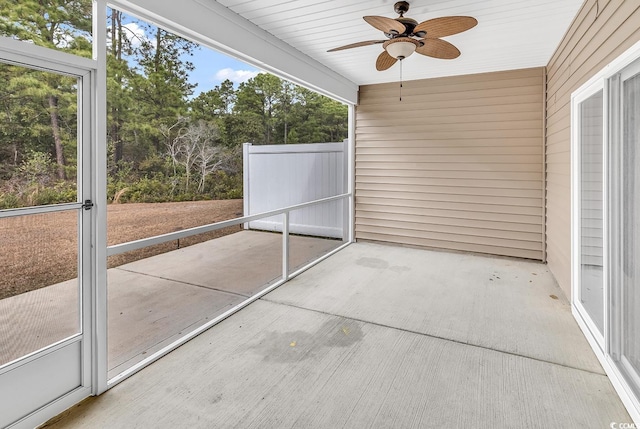 unfurnished sunroom featuring ceiling fan and a healthy amount of sunlight