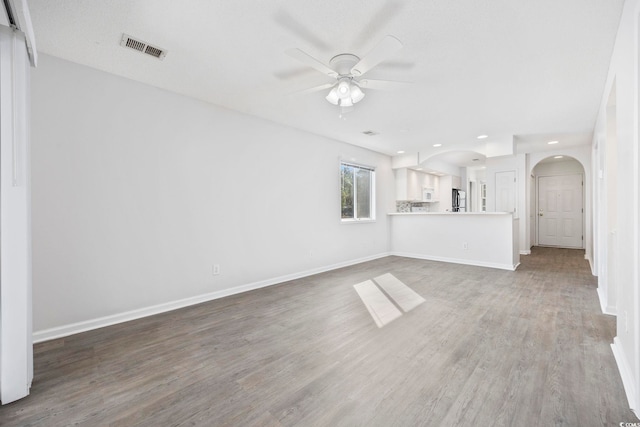 4430 Eastport Blvd Unit L5, Little River, SC 29566 - unfurnished living room with wood finished floors, visible vents, arched walkways, baseboards, and ceiling fan