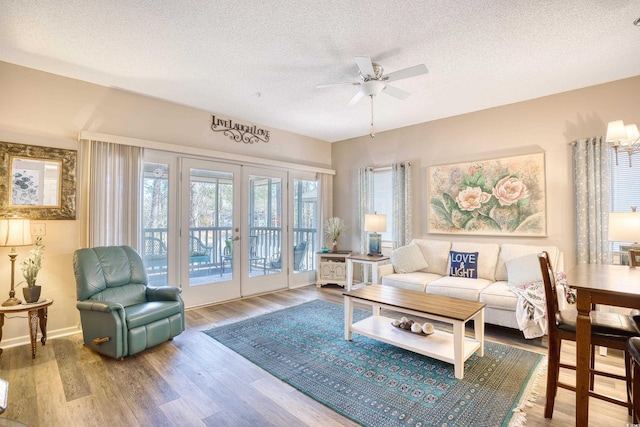 living room with french doors, a textured ceiling, ceiling fan, and wood finished floors