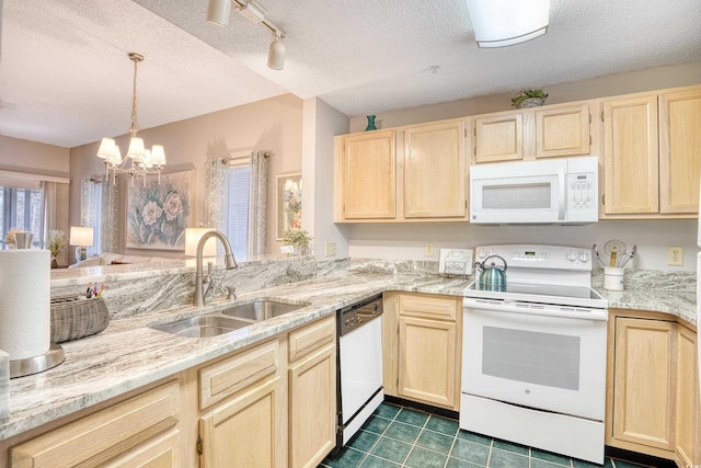 kitchen with light brown cabinets, white appliances, a textured ceiling, and a sink