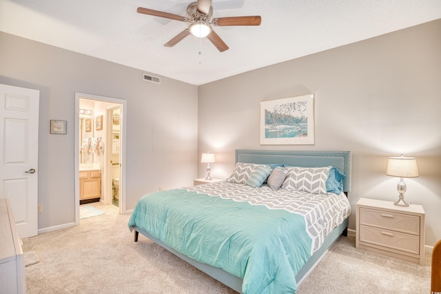 bedroom featuring a ceiling fan, baseboards, visible vents, light carpet, and connected bathroom