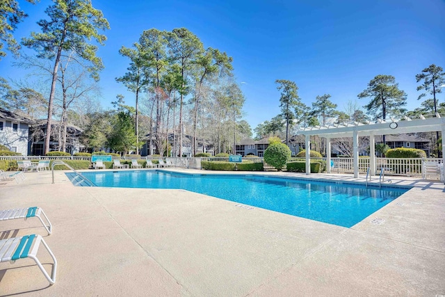 community pool with a patio and fence