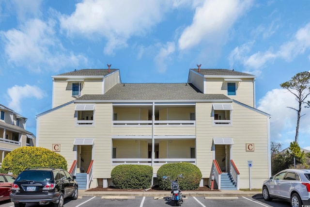 view of property with uncovered parking and entry steps