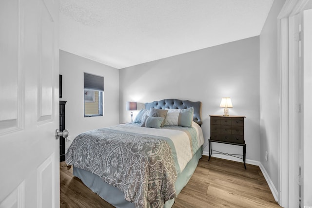 bedroom featuring baseboards and wood finished floors