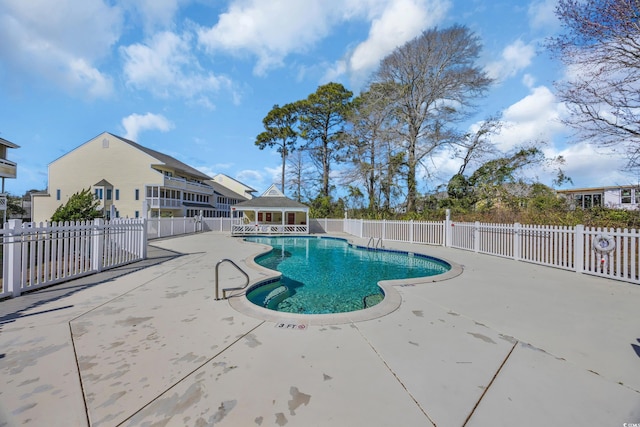 community pool with an outdoor structure, a storage structure, a patio, and fence