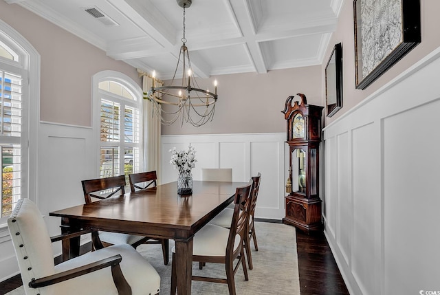 dining space with an inviting chandelier, a decorative wall, visible vents, and beam ceiling