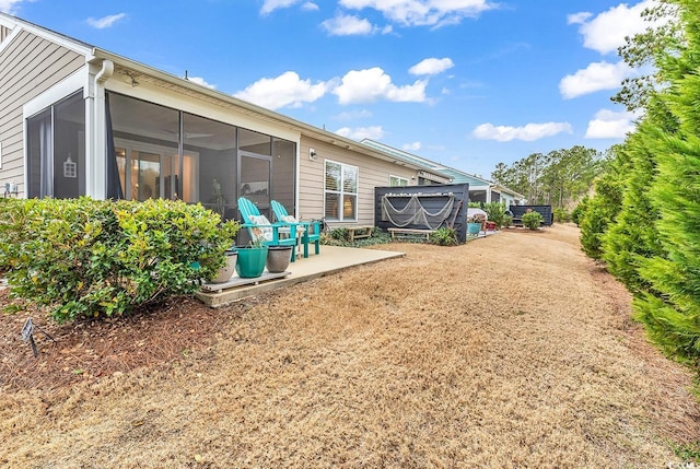 back of house with a sunroom and a patio area