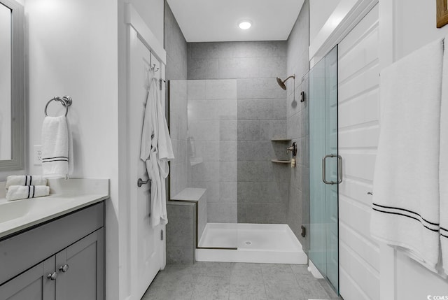 full bath with vanity, a shower stall, and tile patterned flooring