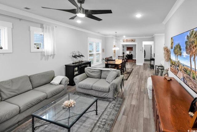 living room with visible vents, ceiling fan, ornamental molding, recessed lighting, and wood finished floors