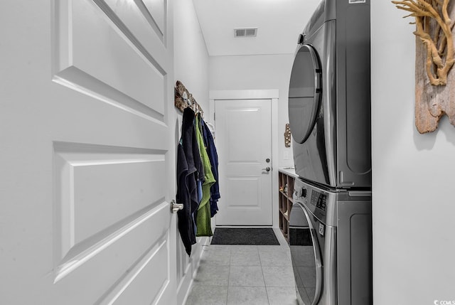 laundry room with visible vents, stacked washer and clothes dryer, light tile patterned flooring, and laundry area