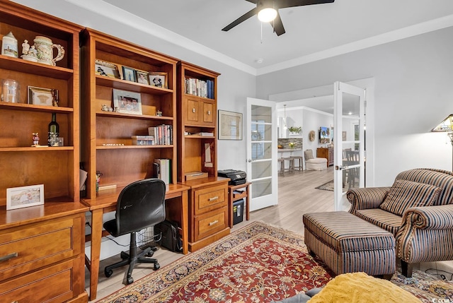 office featuring crown molding, light wood-style flooring, french doors, and ceiling fan