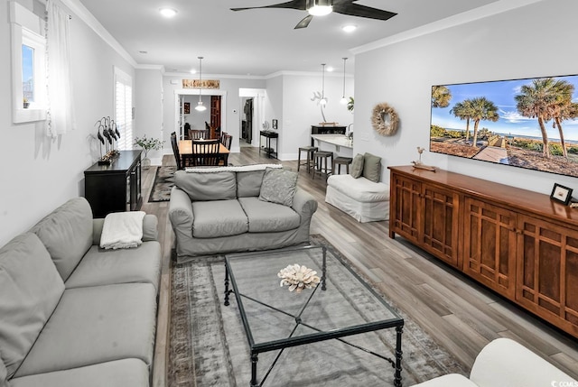 living room with recessed lighting, light wood-style flooring, ceiling fan, and ornamental molding