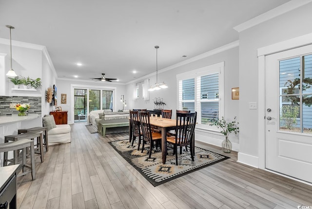 dining space featuring a ceiling fan, baseboards, recessed lighting, crown molding, and light wood-type flooring