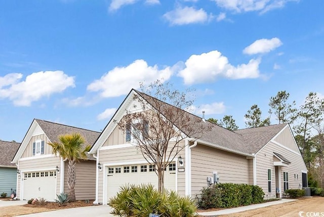 view of front of property with board and batten siding, a shingled roof, a garage, and concrete driveway