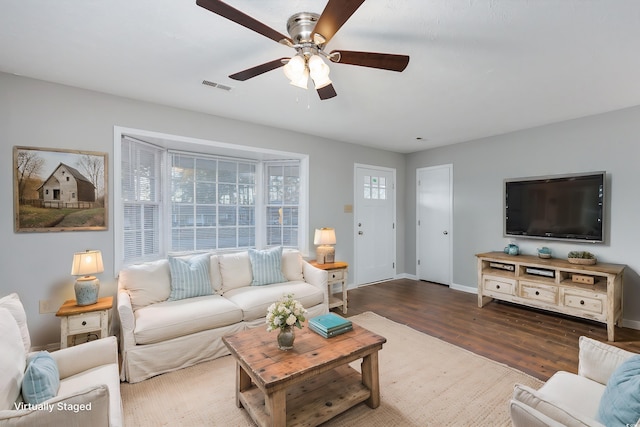 living room with visible vents, a ceiling fan, baseboards, and wood finished floors